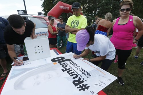 JOHN WOODS / WINNIPEG FREE PRESS Runners sign a poster at a memorial 5km run for Joanne Schiewe, who died yesterday of brain cancer, in Winnipeg's Assiniboine Park Tuesday, August 30, 2016
