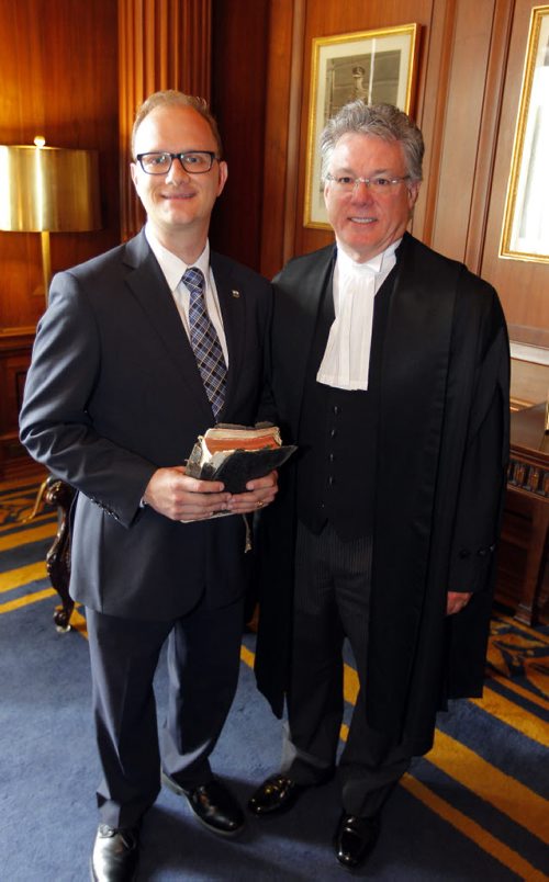 BORIS MINKEVICH / WINNIPEG FREE PRESS Government House Leader Andrew Micklefield, left, was sworn in by Chief Justice of the Court of Queen's Bench of Manitoba Glenn D. Joyal, right, today in the Blue Room on the second floor of the Manitoba Legislature. Micklefield was holding his grandfathers old Bible that he used in the swearing in. August 31, 2016