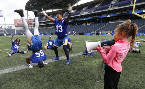 WAYNE GLOWACKI / WINNIPEG FREE PRESS  After the Winnipeg Blue Bombers practice Wednesday at Investors Group Field, some of the players had an opportunity to be put through some additional training by seven year old  Stefanie Gatin, one of Winnipegs top gymnasts in her class. Here she has defensive lineman Jamaal Westerman doing a headstand. She was selected to experience being a professional football coach  for a day to exemplify Mattel's Barbie dolls' theme "You Can Be Anything" campaign. The news release states "Barbie, the doll whos experienced 180 careers and counting, believes that young girls can live out any career they can imagine." August 31 2016
