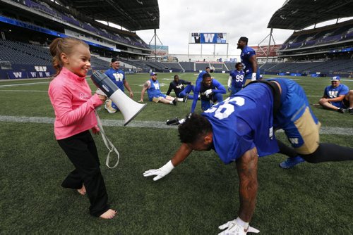 WAYNE GLOWACKI / WINNIPEG FREE PRESS  After the Winnipeg Blue Bombers practice Wednesday at Investors Group Field, some of the players had an opportunity to be put through some additional training by seven year old  Stefanie Gatin, one of Winnipegs top gymnasts in her class. Here she has defensive lineman Justin Cole crawling. She was selected to experience being a professional football coach  for a day to exemplify Mattel's Barbie dolls' theme "You Can Be Anything" campaign. The news release states "Barbie, the doll whos experienced 180 careers and counting, believes that young girls can live out any career they can imagine." August 31 2016