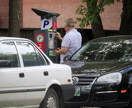 PHIL HOSSACK / WINNIPEG FREE PRESS -  Motorists plug the meter downtown Winnipeg Wednesday. See story.  August 31, 2016