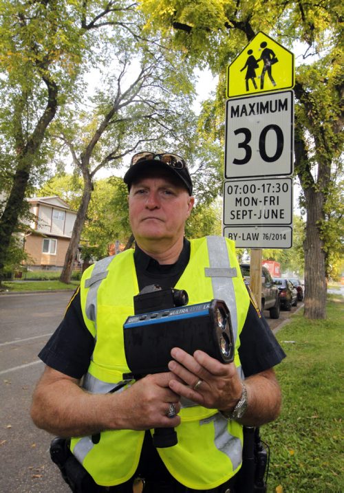BORIS MINKEVICH / WINNIPEG FREE PRESS SCHOOL ZONE SPEED ENFORCEMENT - Const. Ray Howes enforces the 30km/hr school zone on Bannatyne Ave. near Lydia Street. In this photo he poses at the sign where the zone starts. Sept. 1, 2016