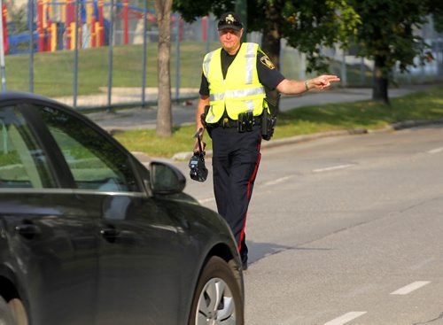 BORIS MINKEVICH / WINNIPEG FREE PRESS SCHOOL ZONE SPEED ENFORCEMENT - Const. Ray Howes enforces the 30km/hr school zone on Bannatyne Ave. near Lydia Street. The fastest car in the zone was 61km/hr  when the photog was there, and it was a teacher that was driving. Sept. 1, 2016