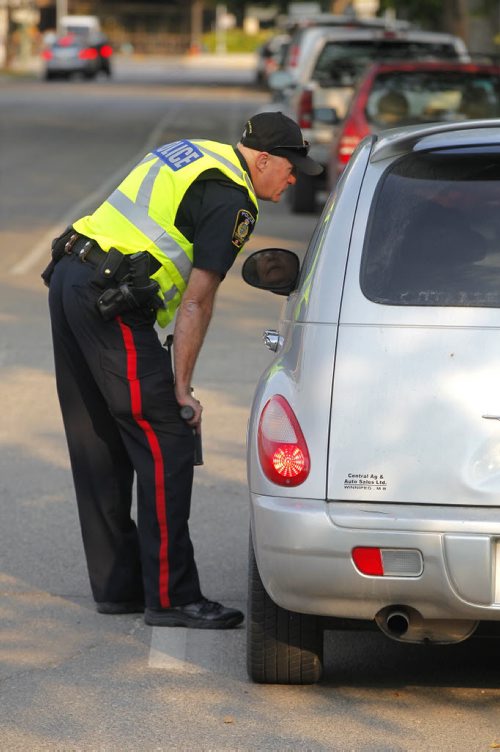 BORIS MINKEVICH / WINNIPEG FREE PRESS SCHOOL ZONE SPEED ENFORCEMENT - Const. Ray Howes enforces the 30km/hr school zone on Bannatyne Ave. near Lydia Street.. Here he talks to one of the drivers he caught. Sept. 1, 2016