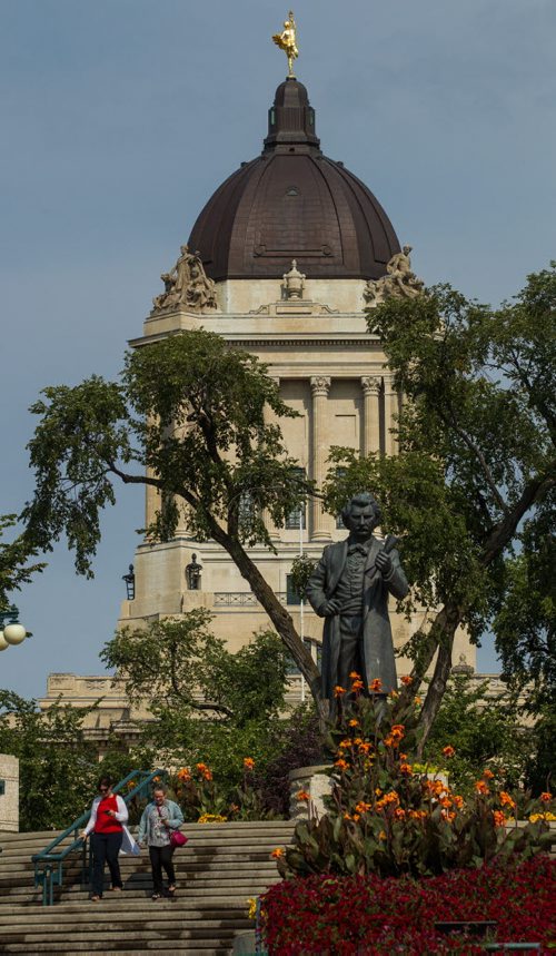 MIKE DEAL / WINNIPEG FREE PRESS Taking a lunch break to enjoy the weather a couple of office workers walk down the steps at the Manitoba Legislative Building to the Assiniboine River past the statue of Louis Riel Thursday.  20160901 - Thursday September 1, 2016