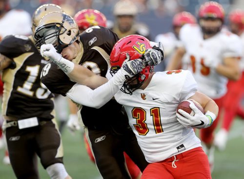 TREVOR HAGAN / WINNIPEG FREE PRESS Manitoba Bisons' Tristen O'Meara tries to tackle Calgary Dinos Quentin Chown during first half CIS football action, Thursday, September 1, 2016.