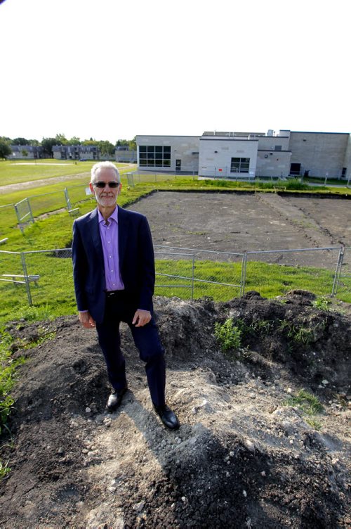 BORIS MINKEVICH / WINNIPEG FREE PRESS Pembina Trails School Division Superintendent of Education Ted Fransen poses on top of a  hill made of the earth that was removed to make room for more new portable classrooms at Fort Richmond Collegiate. Behind him is the build site and the school. For Saturday story on overcrowding in schools.  NICK MARTIN STORY. Sept. 2, 2016