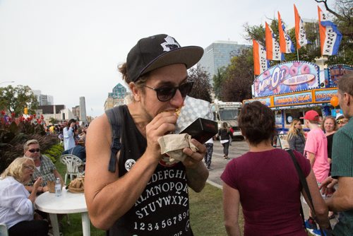 Michael Kowalczyk enjoys his hotdog from Kyu Grill at the Food Truck Wars, part of Many Fest. September 10, 2016 (GREG GALLINGER / WINNIPEG FREE PRESS)