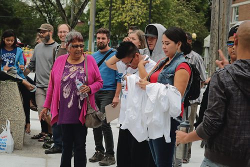 Canstar Community News Della Owens (left, in pink) and Helen Knott (right, in red) stand amidst the crowd at Meet Me at the Bell Tower gathering on Sept. 8, 2017.