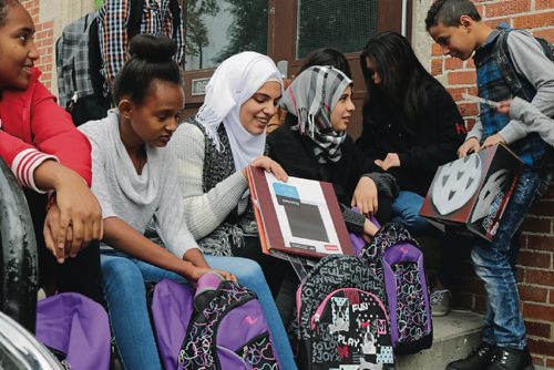 Canstar Community News Newcomer students at Hugh John School go through things they got in a backback donated by Tools for School on Sept. 13, 2016. (Ligia Braidotti/Canstar Community News)