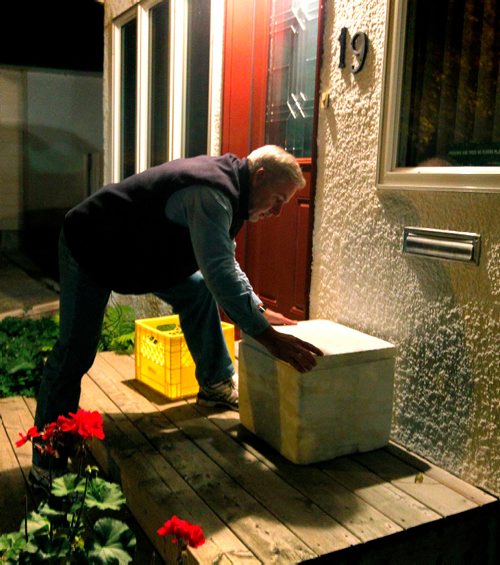 BORIS MINKEVICH / WINNIPEG FREE PRESS
49.8 INTERSECTION - Milkman Garry Peters works his route in the south part of Winnipeg super early Monday Morning. He works for Saputo Inc. (a Montreal-based Canadian dairy company). This customer has a cooler on the front steps that he puts the milk in. DAVE SANDERSON STORY. Sept. 19, 2016