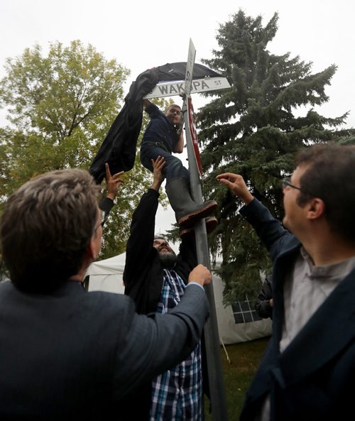 TREVOR HAGAN / WINNIPEG FREE PRESS
St.Vital councillor Brian Mayes, left, and Idris Elbakri, president of the Manitoba Islamic Association, right, watch as Jadd Kasas is hoisted up to help reveal a new sign honouring the Pioneer Mosque as it celebrates its 40th anniversary, Sunday, September 25, 2016.