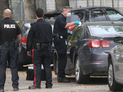 JOE BRYKSA / WINNIPEG FREE PRESS Winnipeg Police and emergency crews are on the scene of College Ave where they have located two bodies in a car parked on the street- Two neighbors verified the discovery.  Police identification officer dusts the car for fingerprints -The car was towed from the street to an undisclosed location to remove the bodies.Oct 03, 2016 -(See Carol Sanders story)