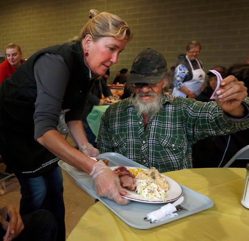 WAYNE GLOWACKI / WINNIPEG FREE PRESS
Volunteer Laurie James serves a meal to a guest at the annual Thanksgiving Feast at the Agape Table Friday morning. About 400 are expected to attend for the ham dinner meal, the lineup started an hour before the doors opened. Oct. 7 2016