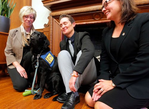 BORIS MINKEVICH / WINNIPEG FREE PRESS
(L-R) Pacific Assistance Dog Society executive director Laura Watamanuk, Milan's handler Vivian Bott, and Justice Minister Heather Stefanson pose for a photo. Milan, a three-year-old black Labrador used to comfort crime victims, got a public introduction Friday from Justice Minister Heather Stefanson in Room 104 at the Legislative Building. Oct. 7, 2016