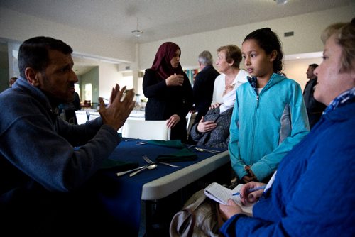 MIKE DEAL / WINNIPEG FREE PRESS
Aya, 10, translates for her father, Kamal (left) and mother, Fatima (centre) during an interview at a potluck supper hosted by Refuge Winnipeg for the three Syrian refugee families who arrived here last October and all the people who privately sponsored them Monday afternoon at the First Unitarian Universalist Church of Winnipeg.
161010 - Monday, October 10, 2016 - 

