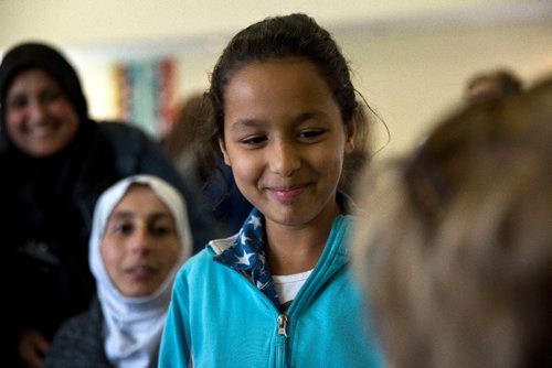 MIKE DEAL / WINNIPEG FREE PRESS
Aya, 10, translates for her parents during an interview at a potluck supper hosted by Refuge Winnipeg for the three Syrian refugee families who arrived here last October and all the people who privately sponsored them Monday afternoon at the First Unitarian Universalist Church of Winnipeg.
161010 - Monday, October 10, 2016 - 

