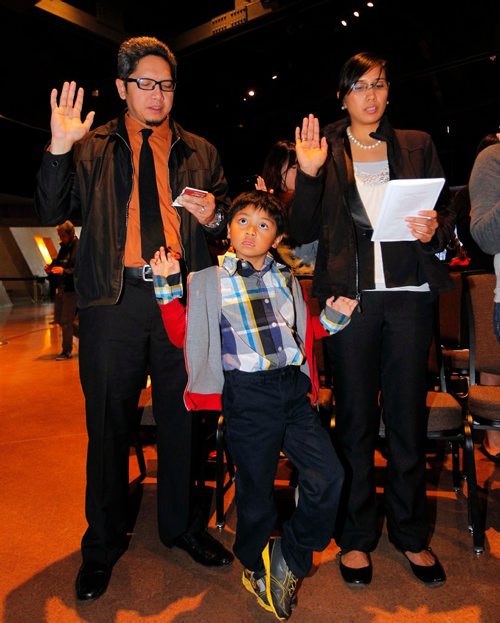 BORIS MINKEVICH / WINNIPEG FREE PRESS
In celebration of Citizenship Week (October 10-16), a special citizenship ceremony at the Canadian Museum of Human Rights took place today. In this photo L-R Luther Maghinang Laya, Dean Linus Marzan Laya, and Dyana Victoria Marzan Laya take the citizenship oath. Oct. 11, 2016