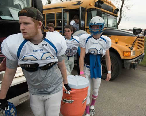DAVID LIPNOWSKI / WINNIPEG FREE PRESS

Oak Park Raiders players carry equipment to the field at Charlie Krupp Stadium before playing the Sisler Spartans Friday October 14, 2016, less than a week after their equipment storage unit went up in flames.