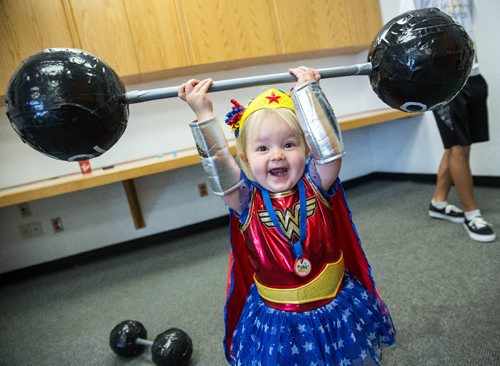 MIKE DEAL / WINNIPEG FREE PRESS
Kierstin Bage, 2, lifts a massive set of weights in an amazing show of strength during a "Superhero Brunch" at the Caboto Centre Sunday morning. The event was put on as a fundraiser for a new non-profit organization called Frosting Foundation which provides birthday party supplies to children who are in the hospital. 
161016 - Sunday, October 16, 2016 - 

