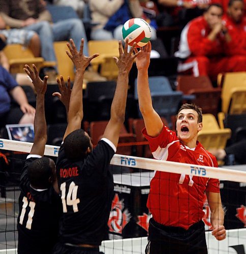 BORIS MINKEVICH / WINNIPEG FREE PRESS  080206 Team Canada's #11 Gavin Schmitt at the net against Team Trinidad &amp; Tobago defenders #11 Jose M. Caceres and #14 Isaias Minaya during international volleyball action at the U of M.