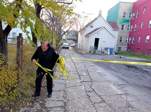BORIS MINKEVICH / WINNIPEG FREE PRESS
BREAKING NEWS - Police and fire investigators on scene at 700 Sherbrook at the scene of an overnight fire. In this frame a uniformed police officer sets up a police tape in the back of the house. Oct. 25, 2016