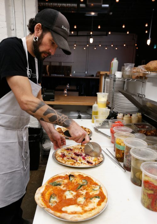 
WAYNE GLOWACKI / WINNIPEG FREE PRESS


Restaurant Review of  the PEG Beer Co. on Pacific Ave.  Chef Aron Epp slices a Roasted Beet Flatbread, a Margherita Flatbread in foreground. Alison Gillmor story Oct. 25 2016