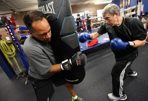PHIL HOSSACK / WINNIPEG FREE PRESS -  Tim Hague holds tight as Syd Weiderman pummels a heavy bag  during a workout for "Counter Punch" a boxing program for Parkinson's patients. Both men are afflicted.  See Jeff Hamilton's story.  November 1, 2016