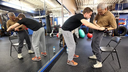PHIL HOSSACK / WINNIPEG FREE PRESS -  Trainer Braden Pyper (left) tightens a harness around  Tadashi Orui prepping for "Counter Punch" a boxing program for Parkinson's patients. Brayden will stabilize Tadashi using the harness during the workout. See Jeff Hamilton's story.  November 1, 2016