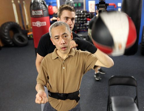 PHIL HOSSACK / WINNIPEG FREE PRESS -  Tadashi Orui works the speed bag with assistance from trainer Braden Pyper during a workout for "Counter Punch" a boxing program for Parkinson's patients.  See Jeff Hamilton's story.  November 1, 2016