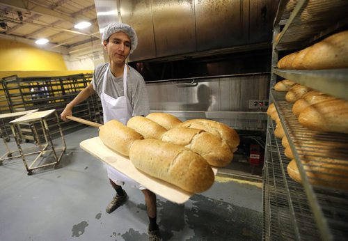 JASON HALSTEAD / WINNIPEG FREE PRESS

Employee Justin Ross puts loaves of rye onto a cooling rack at KUB Bakery on Erin Street in the West End on Nov. 2, 2016. KUB Bakery has been making Winnipeg-style Rye bread, using virtually the same recipe, since 1923. (See Sanderson The City story for Sunday, Nov. 6, 2016)