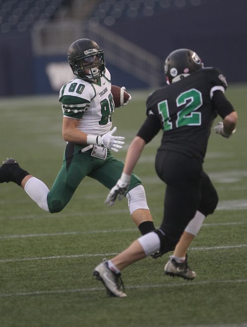 JOE BRYKSA / WINNIPEG FREE PRESS  Vincent Massey Collegiate Trojans Jude Tanghe runs with the ball as Murdoch MacKay Clansmen Riley Mikkelson gives chase during the first half of action Friday night at IGF Field during the semi finals of the Winnipeg High School Football League  -Nov 04, 2016 -( See Scotts  story)
