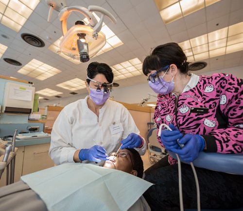 DAVID LIPNOWSKI / WINNIPEG FREE PRESS 

Dr. Karina Gamboa (left) and Dr. Carla Cohn (right) work on Mwashite Mbekalo of Tanzania at the University of Manitoba's College of Dentistry Saturday November 5, 2016. The Manitoba Dental Association and the University of Manitoba's College of Dentistry hosted OPEN WIDE, a day of free dental services for refugees.