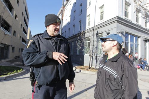 BORIS MINKEVICH / WINNIPEG FREE PRESS
MAIN STREET BEAT COP - Policeman Kevin Burkett, left, walks the beat down on Main Street near Henry Ave. Here he interacts with some people who frequent the area. Jen Zoratti story. Nov 15, 2016