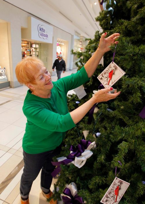 BORIS MINKEVICH / WINNIPEG FREE PRESS
STANDUP - Roberta Popoff hangs a card in memory of her husband Jake Popoff who died this September. Nov 24, 2016

**FROM PRESS RELEASE -THE MEMORY TREE THAT KEEPS GROWING
 
Palliative Manitoba  Helping you live today.

Winnipeg, Manitoba: The holiday season is traditionally a time of joy for most. But, for those grieving, it can inspire feelings of loss, loneliness and social isolation. Many grieving people feel out of step with the world around them, yet are reluctant to admit their pain. The Memory Tree provides a tangible way to acknowledge and remember a person who has died. Individuals write their personal message on a beautiful card and hang it on the Memory Tree, displayed prominently at St. Vital Centre during the holiday season.

Courtesy of a United Way of Winnipeg Day of Caring in partnership with Manitoba Hydro and St. Vital Centre. 

This year marks the 24th anniversary for the Palliative Manitoba Memory Tree.  In 2015, volunteers were on hand to provide support to 1874 visitors who placed 1776 cards on the tree, of which 380 were childrens cards.