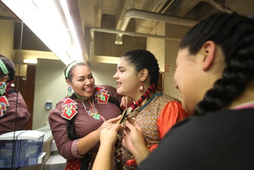 
RUTH BONNEVILLE / WINNIPEG FREE PRESS

Jingle dress dancers Autumn Monkman (left), Iroc Levasseur (centre) and Ainsley Clarke help Levasseur   with her costume in the washroom at the U of W as they prepare to perform in a round dance during half time for  the Canada West Basketball tournament at the U of W Dr. David F. Anderson Gymnasium Thursday.  
Standup 
November 24, 2016