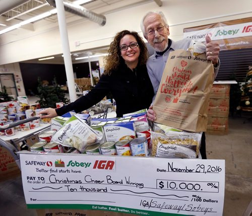 WAYNE GLOWACKI / WINNIPEG FREE PRESS
Natalina Porpiglia-Dafnis, Specialist with Sobeys presented Kai Madsen, Executive Director of the Christmas Cheer Board a $10,000 company donation cheque from Safeway, Sobeys and IGA at the launch of the annual grocery donation bag campaign that is included in the Winnipeg Free Press newspaper. The Tuesday  event was held at the Christmas Cheer Board. Doug Speirs story November 29 2016