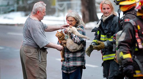 PHIL HOSSACK / WINNIPEG FREE PRESS -   Aaron and Nicole Wolf care for three of their five cats after escaping a buring Marland Apartment building Wednesday afternoon. Aaron was in their 2nd floor apartment when he saw smoke coming up through their floor from the burning suite below. At least one woman was taken to hospital after being carried out of the building. See Bill Redekopp story. November 30, 201