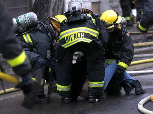 PHIL HOSSACK / WINNIPEG FREE PRESS -   Firefighters lay a woman on the street in front of a burning Maryland Street Apartment building Wednesday afternoon. At least one woman was taken to hospital after being carried out of the building. See Bill Redekopp story. November 30, 201