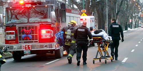 PHIL HOSSACK / WINNIPEG FREE PRESS -   City Paramedics and a firefighter wheel a victim away from a Maryland Street Apartment building Wednesday afternoon. At least one woman was taken to hospital after being carried out of the building. See Bill Redekopp story. November 30, 201