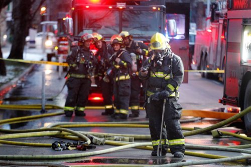 PHIL HOSSACK / WINNIPEG FREE PRESS -   City firefighters wait in que to rotate into a burning Maryland Street Apartment building Wednesday afternoon. At least one woman was taken to hospital after being cartried out of the building. See Bill Redekopp story. November 30, 201