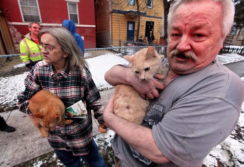 PHIL HOSSACK / WINNIPEG FREE PRESS -  Nicole and Aaron Wolf cling to two of their five cats Wedneday afternoon after they escaped a burning Maryland Apartment building. They are caretakers, she was cleaning on the third floor while Aaron was escaping their 2nd floor apartment after smoke and flames started coming through the floor.  At least one woman was taken to hospital after being carried out of the building. See Bill Redekopp story. November 30, 201