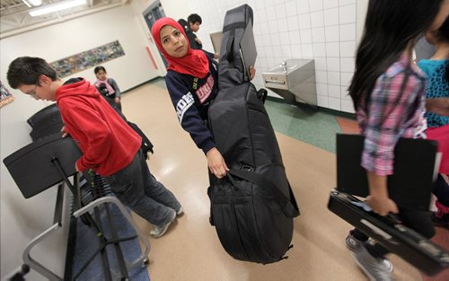 PHIL HOSSACK / WINNIPEG FREE PRESS - Tahani Al Hassan wrangles her double bass into rehearsal. Students from King Edward School  are involved in the WSOs Sistema program, which aims to connect youth in undeserved areas with the pursuit of excellence in music education, spent the afternoon and evening practicing for an upcoming concert. See Melissa Martin's story. December 1, 2016