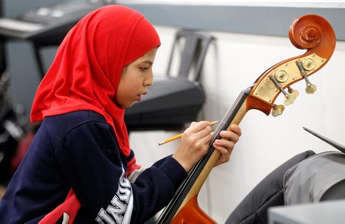 PHIL HOSSACK / WINNIPEG FREE PRESS -Tahani Al Hassan, A  King Edward School student marks her fingering on the neck of a double bass, she and classmates are involved in the WSOs Sistema program, which aims to connect youth in under served areas with the pursuit of excellence in music education, spent the afternoon and evening practicing for an upcoming concert. See Melissa Martin's story. December 1, 2016