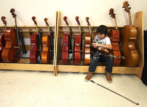 PHIL HOSSACK / WINNIPEG FREE PRESS - 10 yr old Lucas Howard adjusts the chin rest on his violin before demonstrating the instrument Friday afternoon in the Sistema room at King Edward Community School.See Melissa Martin's story. December 1, 2016