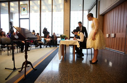 RUTH BONNEVILLE / WINNIPEG FREE PRESS

Chris Herie and his wife Lisa sign the paperwork after being  married at City Hall Friday afternoon.  They are the first couple to be married in a civil ceremony at City Hall.  Their children. son - Tiernan, 5yrs, and daughter - Dahlia, 2yrs, were in the wedding party with friends, family and the media there to capture the moments event.  
See Jen Zoratti's story.  
Dec 2, 2016
