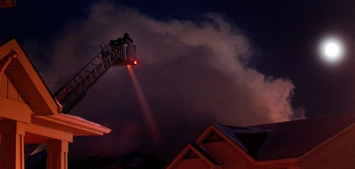PHIL HOSSACK / WINNIPEG FREE PRESS -  Fire crews battling a blaze in Bridgewater soak a house from an aerial platform while the full moon lends a hand lighting up the sky.  December 12, 2016