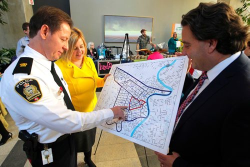 BORIS MINKEVICH / WINNIPEG FREE PRESS
Winnipeg Police Service Announces Downtown Safety Strategy. Press conference took place on the main floor of the Manitoba Hydro building downtown. L-R WPS Division 11 Commander Inspector Jim Anderson, CentreVenture CEO Angela Mathieson (in yellow), and Downtown Winnipeg BIZ Executive Director Stefano Grande look at the map outlining where the new patrols will work. ALDO SANTIN STORY. Dec. 15, 2016