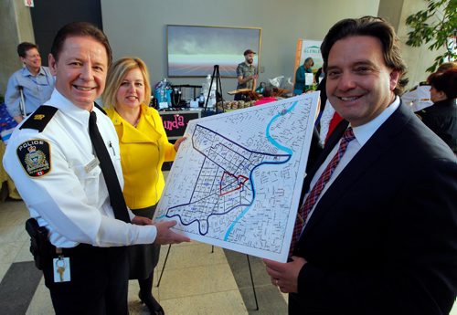 BORIS MINKEVICH / WINNIPEG FREE PRESS
Winnipeg Police Service Announces Downtown Safety Strategy. Press conference took place on the main floor of the Manitoba Hydro building downtown. L-R WPS Division 11 Commander Inspector Jim Anderson, CentreVenture CEO Angela Mathieson (in yellow), and Downtown Winnipeg BIZ Executive Director Stefano Grande look at the map outlining where the new patrols will work. ALDO SANTIN STORY. Dec. 15, 2016