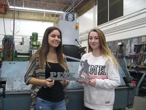 Canstar Community News Dec. 14, 2016 - Murdoch MacKay Grade 10 metal fabrication students Brianna McNeill (left) and Gracie Schroeder show off a custom metal coathanger which they just finished bending into place. Students at Murdoch have been manufacturing and selling custom metal coathangers, proceeds of which go to the United Way of Winnipeg's Koats for Kids campaign. Since 2011, Murdoch MacKay has raised over $10,000 for the campaign. (SHELDON BIRNIE/CANSTAR/THE HERALD)